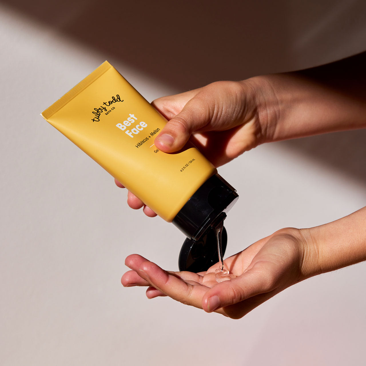 Close up squeezing Best Face Gel Cleanser product into hand